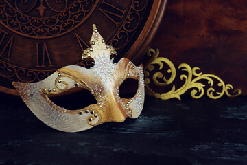 Photo of black with gold elegant Venetian mask over grunge background