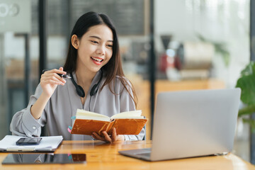 Beautiful Young Freelancer Woman Using Laptop Computer Sitting At Cafe Table. Happy Smiling Girl Working Online Or Studying And Learning While Using Notebook. Freelance Work, Business People Concept