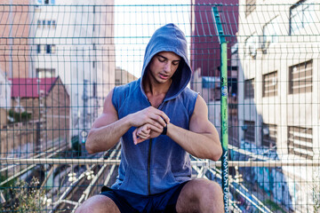 Fit man checking smart watch wearable technology sport smartwatch on fitness run walk outside.