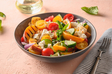 Panzanella salad with tomatoes, bread, cheese and grilled peach. Close up. Italian cuisine. Summer vegetables colorful salad.