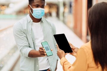 Worker Scanning Visitor's Qr Code On Entrance To Public Place
