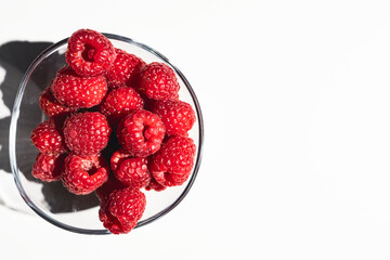 Fresh and ripe raspberries on a white background with copy space