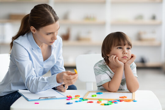 Bored Sad Little Boy Refusing To Cooperate With Teacher, Ignoring Speech Therapist With Letters At Office, Free Space