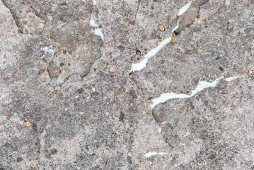 Cracked concrete wall gray cement surface background.cracked grey stone wall in winter.close-up.