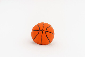 Orange basketball ball lie on the snow close-up copy space.