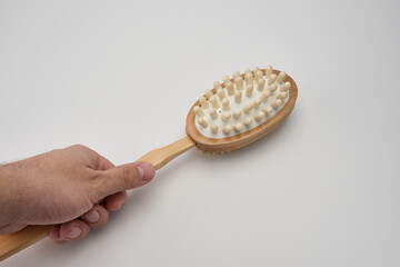 hand holding dry brush massager on white background