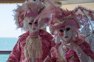 Couple en habits vénitien rose et blanc au carnaval