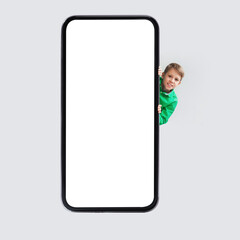 Cheerful Boy Posing Near Huge Phone Empty Screen, Gray Background