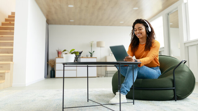 Portrait of smiling black woman using tablet at home