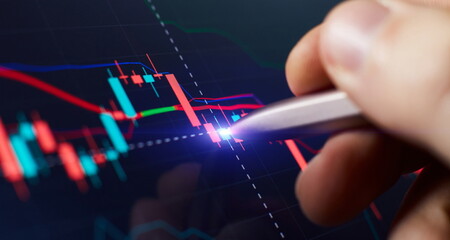 Financial chart with pen, stock analysis data for business background on digital screen. Graphs of...