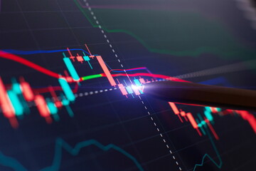Financial chart with pen, stock analysis data for business background on digital screen. Graphs of...