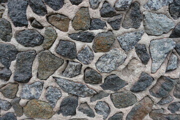 Close view of wall with dark gray gravel pebble dash