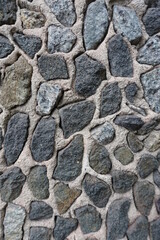 Surface of wall with dark gray gravel pebble dash