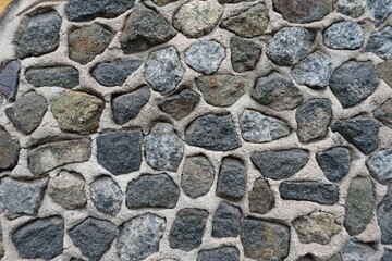 Texture of wall with dark gray gravel pebble dash