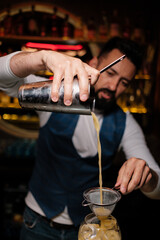 A man learns how to make cocktails at the bar. First day at work as a bartender.