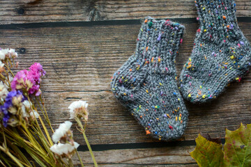 Fototapeta na wymiar Chunky gray newborn socks, made of soft cotton yarn