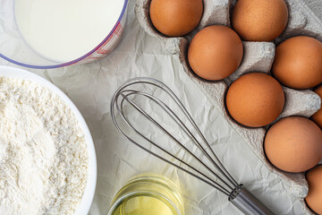 eggs milk flour vegetable oil and whisk top view