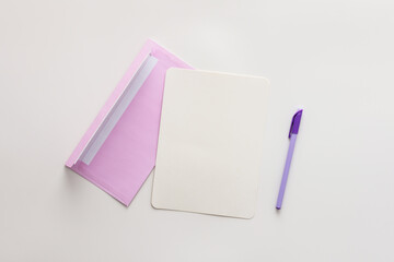 Violet envelope with blank paper and pen, greeting card or invitation mockup, top view, copy space
