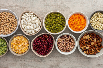 Different types of legumes in bowls, yellow and green peas, mung beans and chickpeas , colored...
