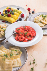 Assortment of Italian pasta dishes. Different types of tortellini, ravioli, dumpling, pierogi, crepes on wooden   background.