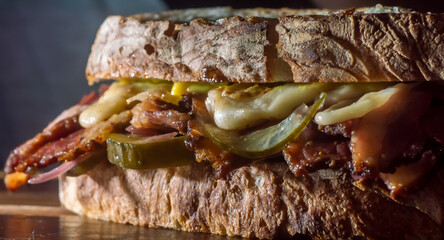 Pastrami sandwhich on a wooden tablet with delicious meet on baguette bread with cheese,copy space...