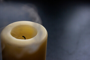 Photo of two smouldering candles on black background