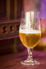 Alcoholic drink beer in a glass glass. Foam on the walls of the vessel. Bar or cafe.