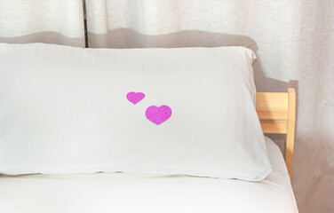 Paper red hearts on a white pillow. A surprise in the bedroom for loved ones.