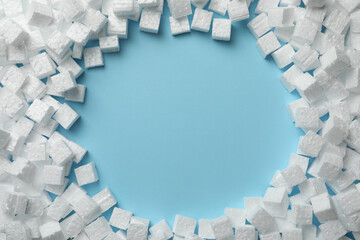 Frame made of styrofoam cubes on light blue background, flat lay. Space for text