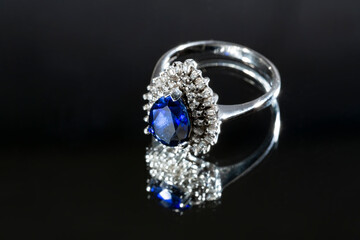 jewelry ring witht big blue sapphir on black coal background
