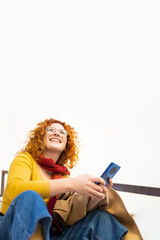 Young curly woman using her smartphone on a beautiful day