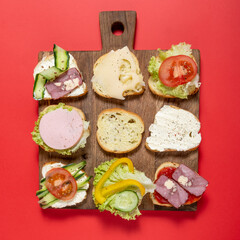 sandwiches on a wooden board and red background