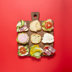 sandwiches on a wooden board and red background