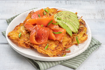 Fried potato pancakes with salmon and sour cream, fritter, roesti, golden crispy crust. Traditional delicious food, breakfast