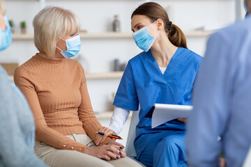 Elderly woman getting support from female worker of nursing home