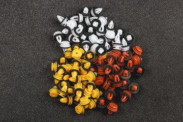 Macro photography of plastic multi-colored clips for a car on a gray background. Car clips, plastic fasteners, multicolored plastic clips on a gray background close-up.Car clips and fasteners.