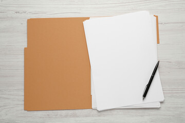 Yellow file with blank sheets of paper and pen on white wooden table, top view. Space for design