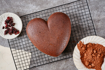 Muffin or bundt cake in the shape of a heart on a bake grid on a gray grunge background. Christmas...