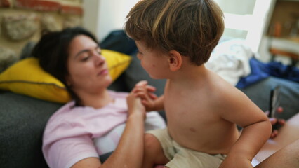 Small boy and mother together candid relationship on sofa