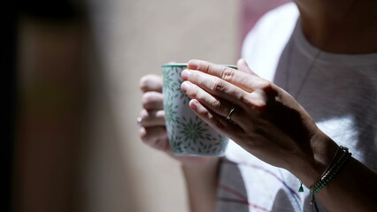 Person hands holding cup of tea or coffee