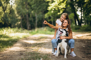 Two sisters with their dog in park