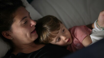 Mother telling bedtime story to toddler mom holding book night routine