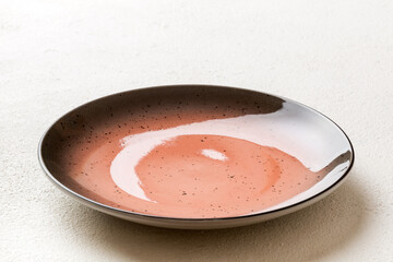 Perspective view of empty red plate on cement background. Empty space for your design