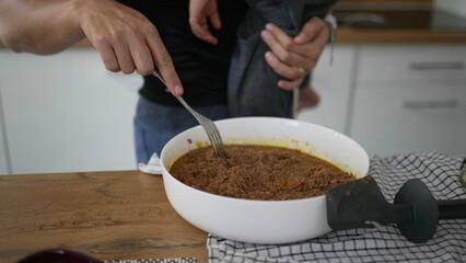 Mother holding son while cooking mom multi-tasking at home preparing food