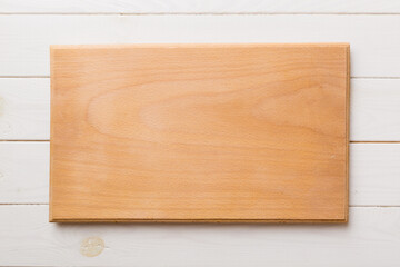 Top view of wooden cutting board on wooden background. Empty space for your design.=