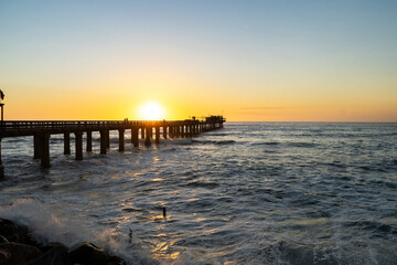 Fototapeta na wymiar Old long wooden jetty at sunset