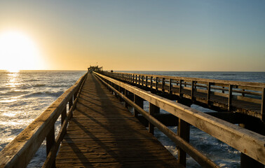 Fototapeta premium Old long wooden jetty at sunset