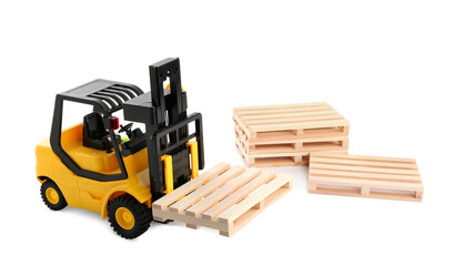 Toy forklift truck with wooden pallets on white background