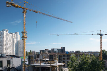 A fragment of the city of Kiev, Ukraine. In the foreground are tower cranes over one of the new buildings, as well as constructed residential and office buildings.