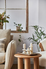 Stylish composition of modern living room interior details. Creative handmade candles on the wooden coffee table. Home staging. Template. Copy space. .